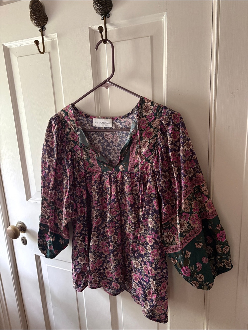 Self Contrast’s Floral Peasant Blouse in Purple, Green, and Pink.